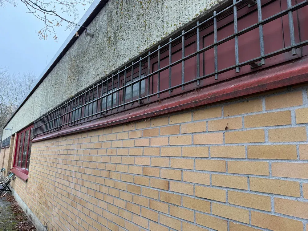 Öffentliche Gebäude: Fensterband mit Gitterschutz an einem Zweckbau